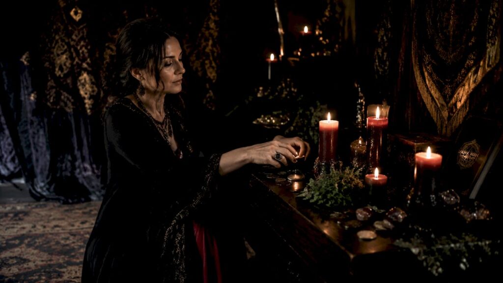 Practitioner arranging money spell ritual altar