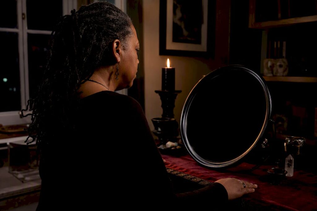 Practitioner gazing into a black scrying mirror