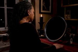 Practitioner gazing into a black scrying mirror