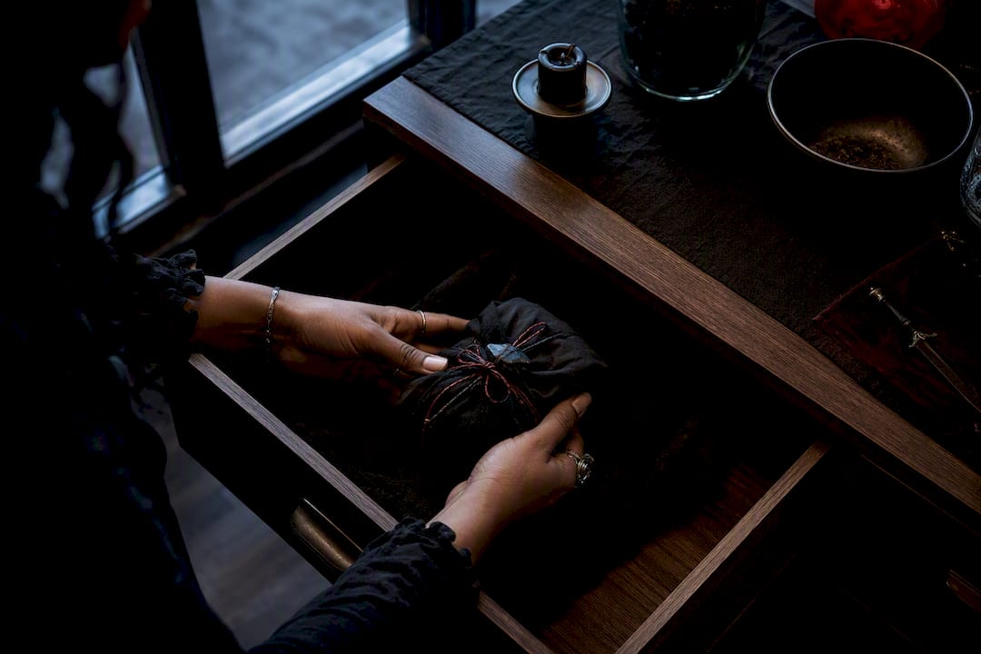 Hands securing a wrapped ritual bundle